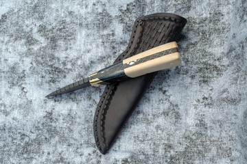 A uniquely designed fixed blade Damascus knife and leather sheath.