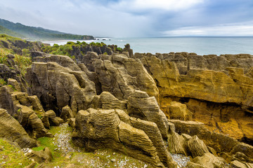 Sea and natural layered rock formations from erosion. Pancake Rocks and Blowholes, Paparoa National Park, West Coast, near Hokitika, New Zealand.
