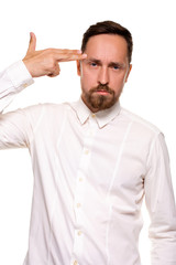 Young man committing suicide with finger gun gesture, shooting himself in head making finger pistol sign, man in white shirt on white background, copy space
