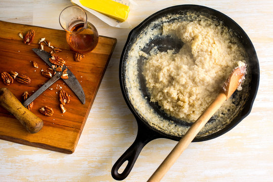 Overhead view of grits and millet with pecans and maple syrup