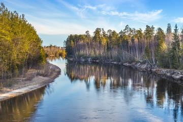 on the banks of the river are trees and reflected in the water