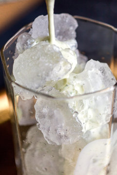 Close up of lassi pouring into the glass 