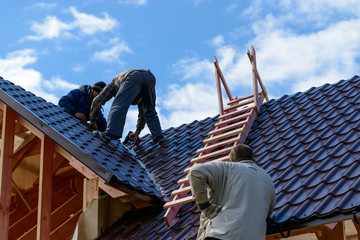 Masters make the roof of the frame house, metal on the roof of a new house