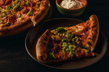 Homemade pizza with chicken and broccoli.