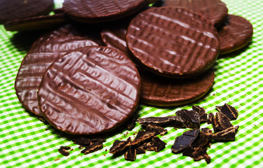 Round chocolate biscuits on green background