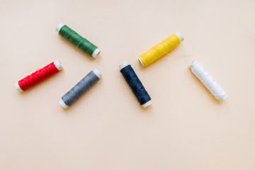 collection of various sewing threads on pastel background. each one is shot separately. knittinng tools.Natural cotton string roll isolated, copy space.Colored thread coils multi colored embroidery