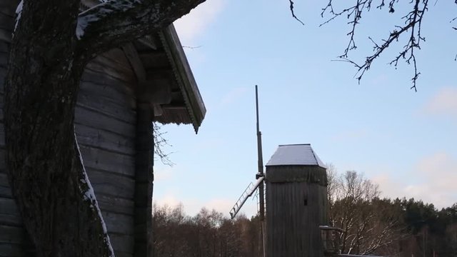 Beautiful dutch windmill near covered in snow with ice on river sunset