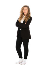 Smiling girl with curly blonde hair, she is standing with her arms crossed, wearing a black suit and white shirt and sneakers