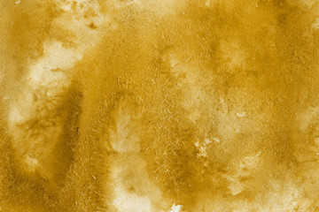 Naklejka premium Gold watercolor texture with abstract washes and brush strokes on the white paper background.