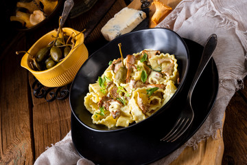 Reginette noodles in cream sauce with fresh chanterelles and capers