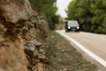 soft focus creative foreshortening of driving car on country side road between trees in park...