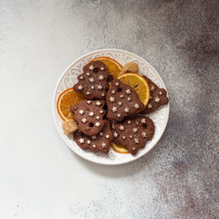 Chocolate cookies on a white plate on grey stone background