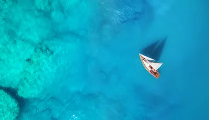 Yacht auf der Wasseroberfläche von oben. Türkisfarbener Wasserhintergrund von oben. Sommermeerblick aus der Luft. Reisekonzept und Idee © biletskiyevgeniy