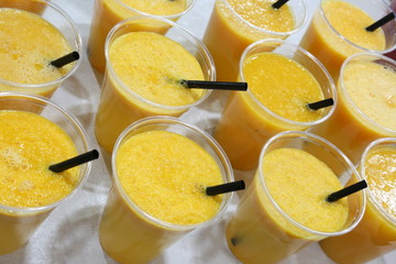 many plastic cups with healthy orange juice