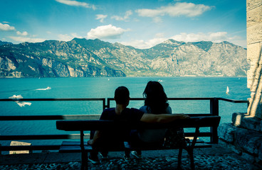 Couple in love on the shores of Garda lake, Malcesine on Garda lake, Italy. In love couple on the waterfront. photo in style lomography.