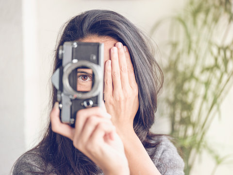 Woman holding camera without lens