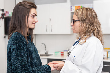Doctor holding patient's hands, helping and empathy concept.