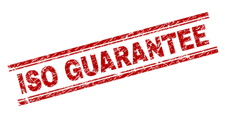 ISO GUARANTEE seal watermark with grunge effect. Red vector rubber print of ISO GUARANTEE text with grunge texture. Text caption is placed between double parallel lines.