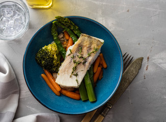 Pike perch fillet with asparagus, broccoli and carrots. Fried fish with stewed greens