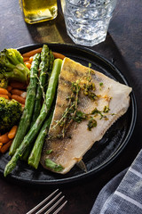 Pike perch fillet with asparagus, broccoli and carrots. Fried fish with stewed greens