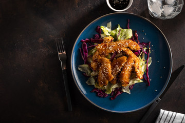 Salad with warm glazing chicken, sprinkled with sesame seeds. Chinese cuisine. Asian culture