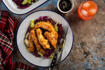 Salad with warm glazing chicken, sprinkled with sesame seeds. Chinese cuisine. Asian culture