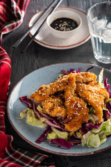 Salad with warm glazing chicken, sprinkled with sesame seeds. Chinese cuisine. Asian culture