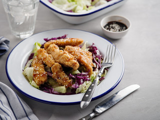Salad with warm glazing chicken, sprinkled with sesame seeds. Chinese cuisine. Asian culture