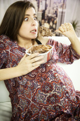 pregnant woman looking like a crazy a big spoon of chocolate ice cream