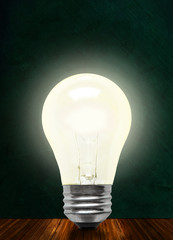 Glowing Incandescent Light Bulb Isolated on Chalkboard Background