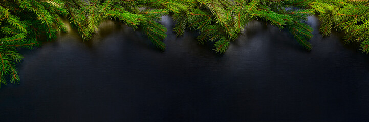 Christmas and Happy New Year holiday background with natural fir spruce, on black background