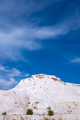 Snow-white hill on the background of blue sky - Pamukkale