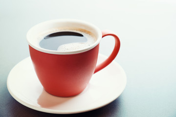 Red cup of coffee and saucer