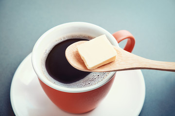 Bulletproof coffee, cup and butter in spoon