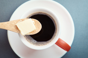Bulletproof coffee, cup and butter in spoon