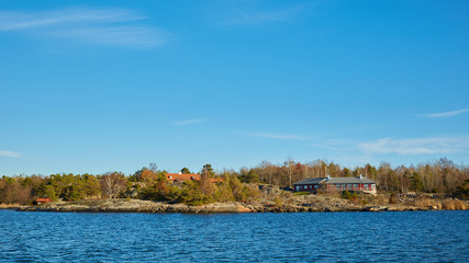 Obraz premium Red house at sea shore in the baltic sea in dull colors in autumn.
