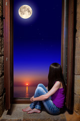 Chica mirando la luna por la ventana