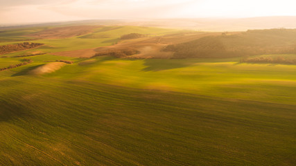 Aerial landscape with green field, sunset light