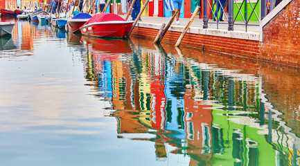 Fototapeta na wymiar Reflection of a colorful houses in water canal, Burano island, Venice, Veneto region