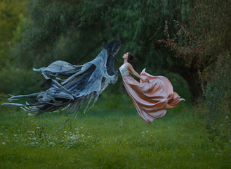 young slender princess with dark hair and neat haircut wore a long luxurious fluttering flying...