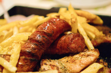 Junk food concept. French fries with sausages.