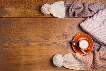 Cocoa, coffee, gift box, fir branch, nuts, cones,  knitted woolen scarf and hat. Winter, New Year, Christmas composition. Cosy autumn-winter concept. View from above, copy spase