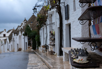 Small traditional trullo houses souvenirs on a street in Alberobello close up, Italy