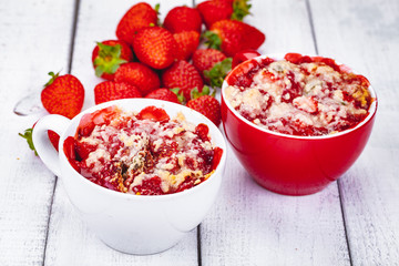 Strawberry crumble in cup on wooden rustic table. Close up
