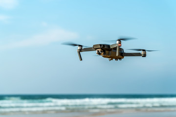 UAV Drone Quadcopter And Digital Camera Flying On Beach