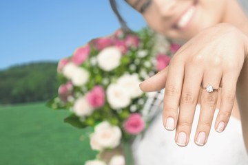 Obraz na płótnie Canvas Beautiful brunette bride in white wedding dress showing her ring