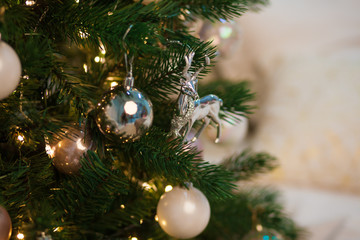 Christmas toy deer on Christmas tree. Elegant New Year toy on branch