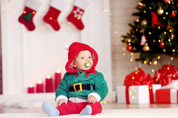 Little boy in christmas costume sitting on floor