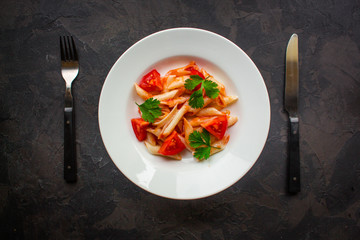 Penne Pasta with Tomato Sauce and Tomatoes. Vegan food.  (dark background). top view. copy space