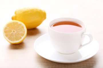 Cup of tea with lemon on wooden table